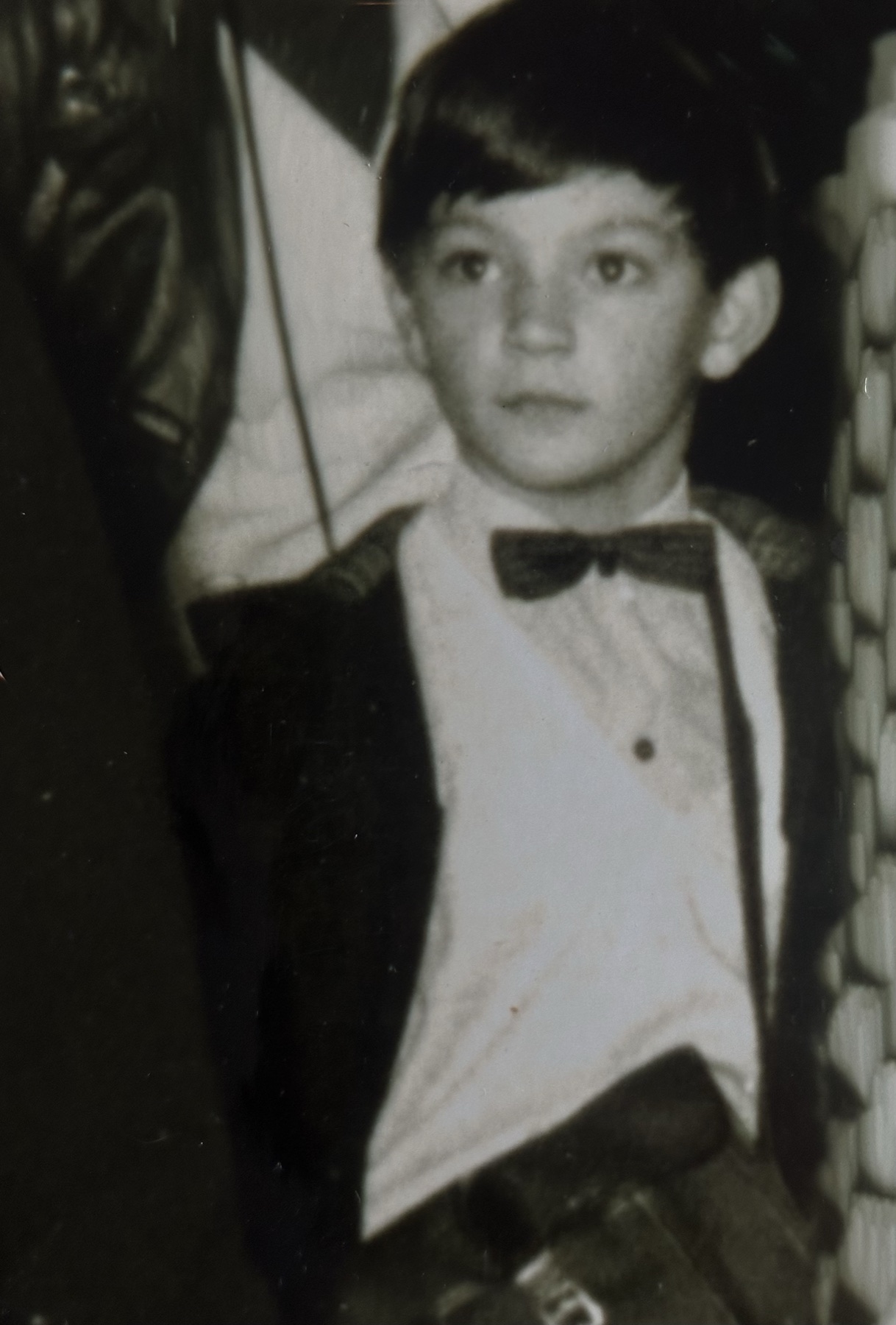 Black and white studio portrait of a young boy in a dicky bow tie