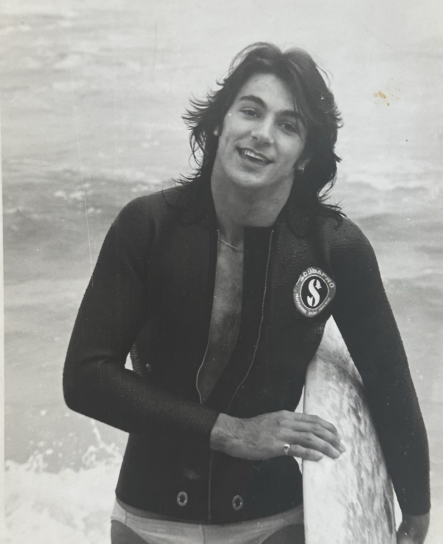 Black and white photograph of a teenager in a wetsuit on an Australian beach