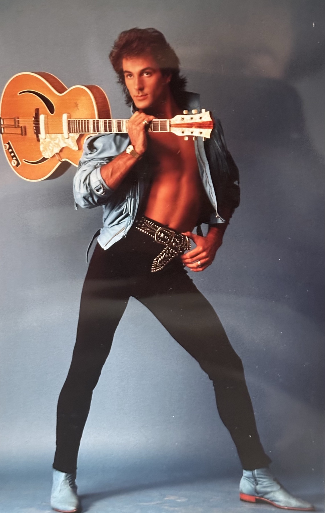 Studio photograph of a guitar resting over the shoulder